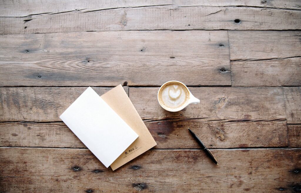 Carnet et tasse posés sur une table en bois